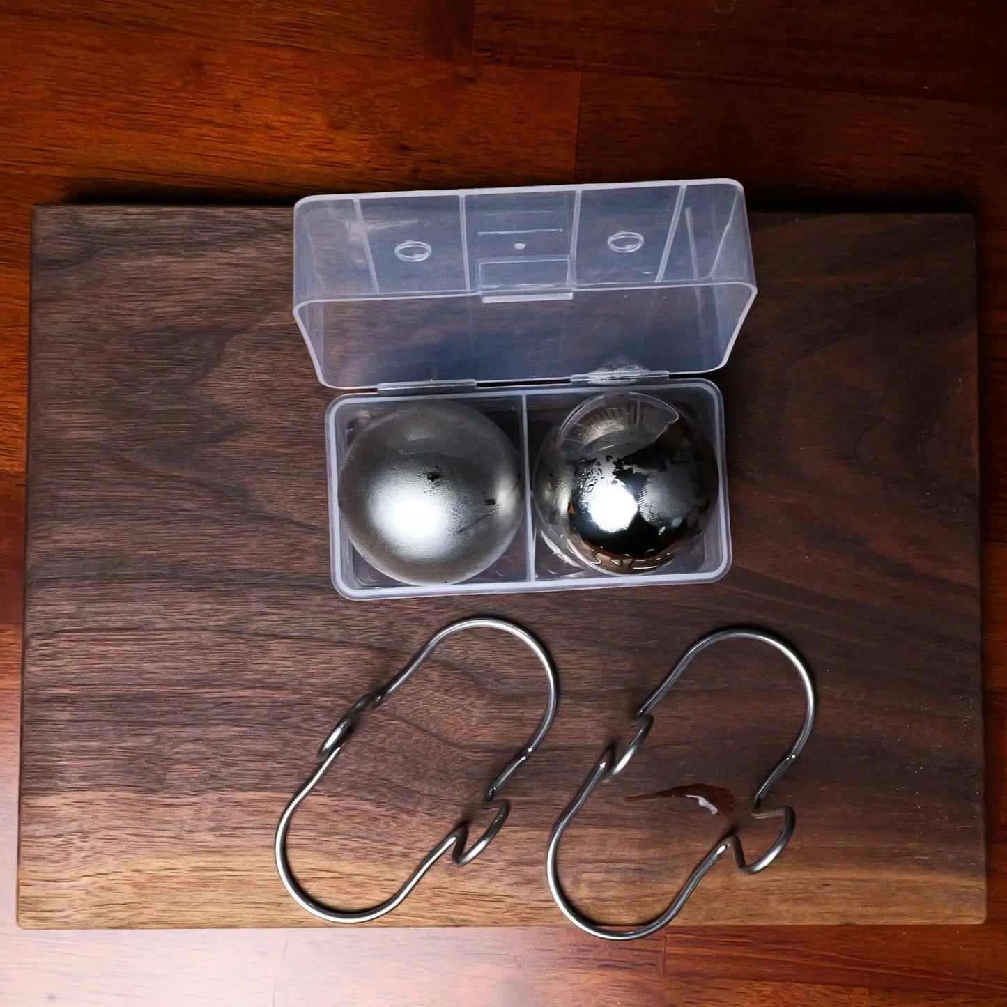 Two XL espresso cooling balls with a clear freezer container from G & J's Finest, designed to keep coffee cold and fresh.