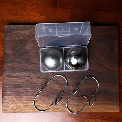 Two XL espresso cooling balls with a clear freezer container from G & J's Finest, designed to keep coffee cold and fresh.